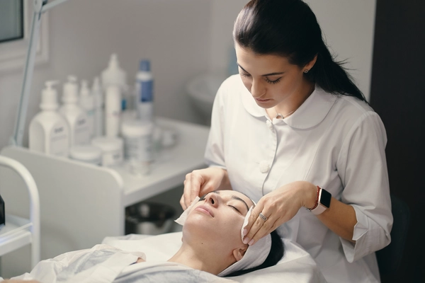 female dermatologist helping woman do skin whitening treatment